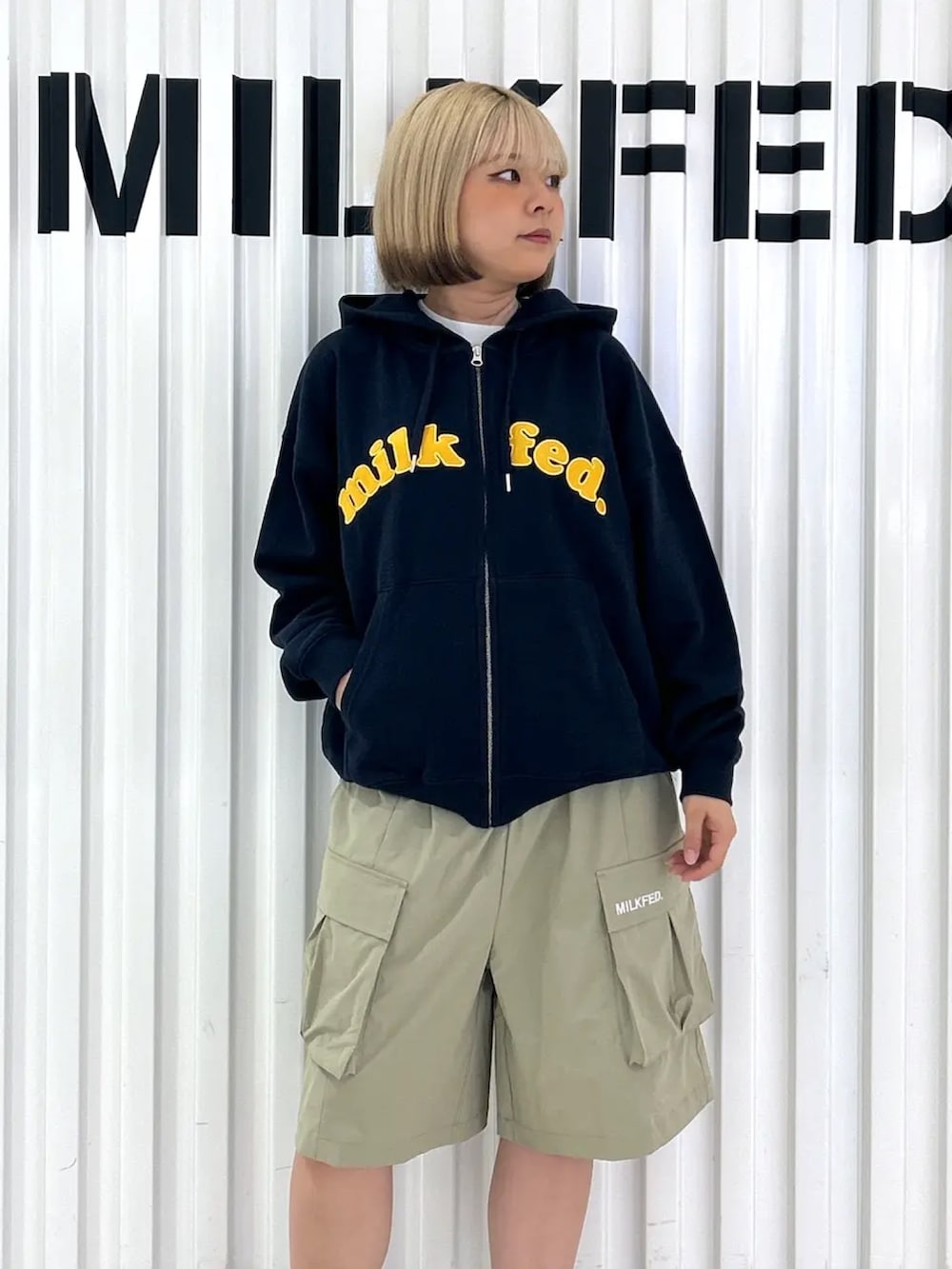 ブルー系のパーカー、ブルー系のバックパック/リュック、グリーン系のラッシュガードを着用したレディースの夏コーディネートの6枚目の写真