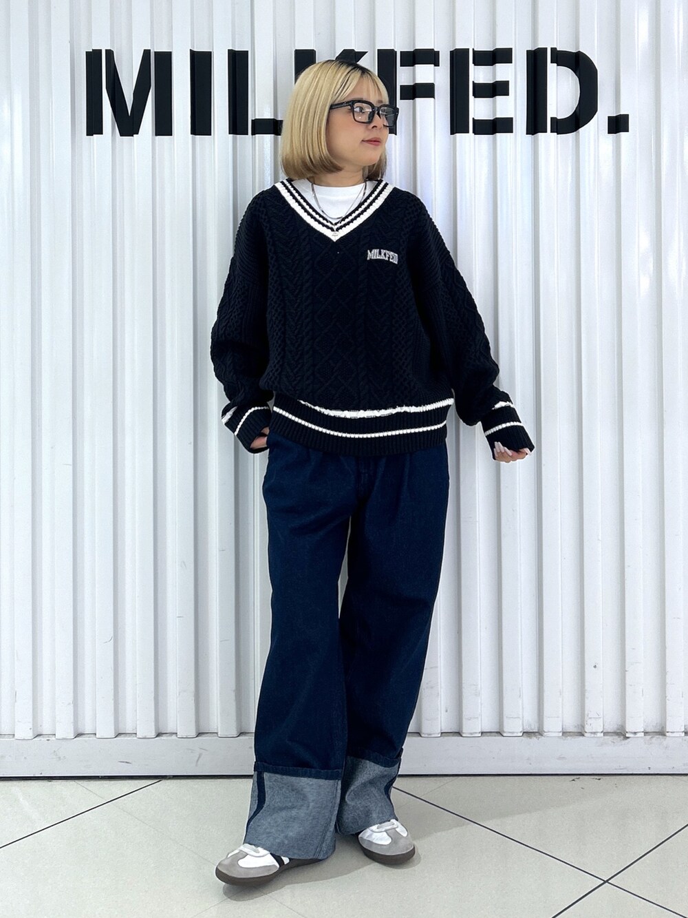 ブルー系のニット/セーター、シルバー系のショルダーバッグ、ブルー系のデニムパンツを着用したレディースの秋コーディネートの3枚目の写真