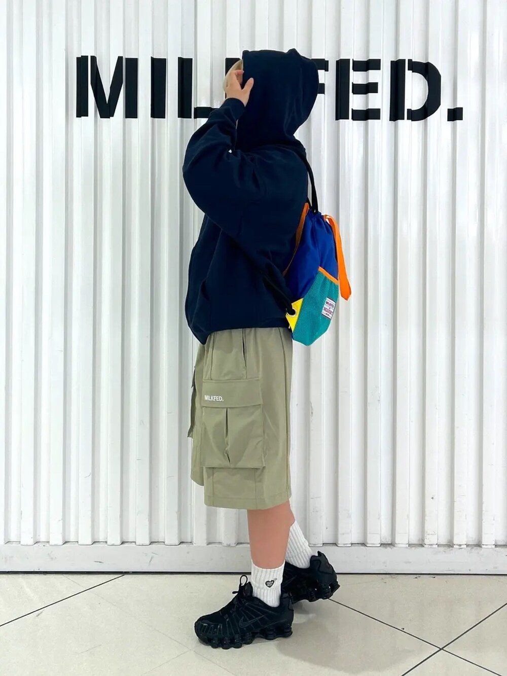 ブルー系のパーカー、ブルー系のバックパック/リュック、グリーン系のラッシュガードを着用したレディースの夏コーディネートの2枚目の写真