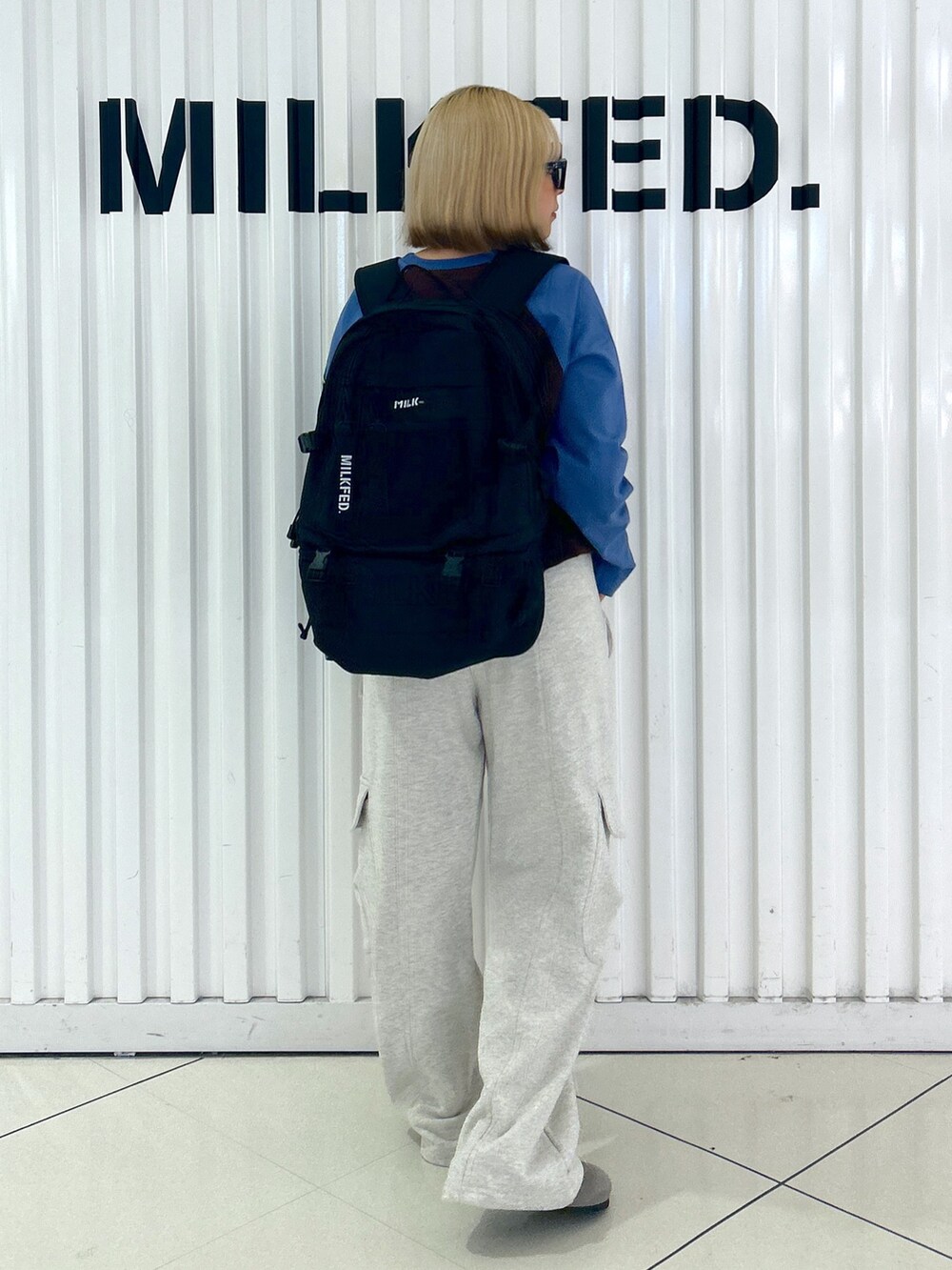 ベージュ系のスウェットパンツ、ブラウン系のTシャツ/カットソー、ブラック系のバックパック/リュックを着用したレディースの夏コーディネートの2枚目の写真