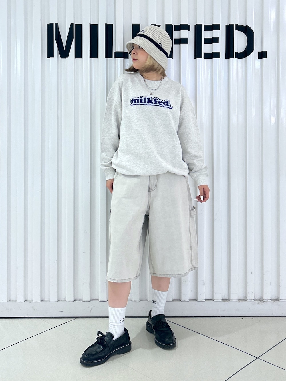 ホワイト系のデニムパンツ、ベージュ系のスウェット、グリーン系のバックパック/リュックを着用したレディースの秋コーディネートの3枚目の写真