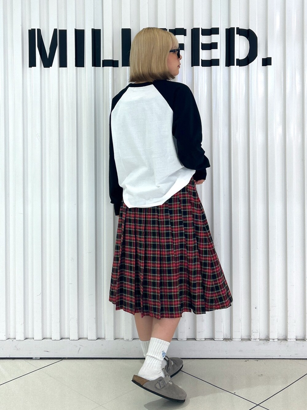 ブラック系のスカート、ホワイト系のTシャツ/カットソー、ブラック系のハンドバッグを着用したレディースの夏コーディネートの3枚目の写真