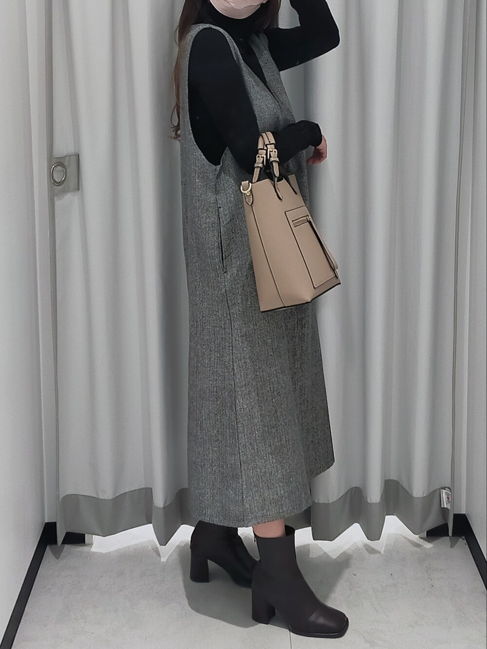 ベージュ系のハンドバッグ、その他のワンピース、ブラック系のニット/セーターを着用したレディースの秋コーディネートの2枚目の写真