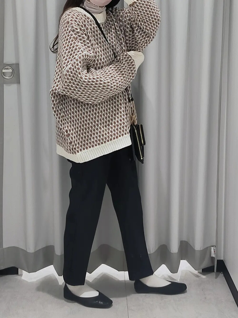 ブラック系のスラックス、グレー系のニット/セーター、ブラック系のパンプスを着用したレディースの秋コーディネートの2枚目の写真