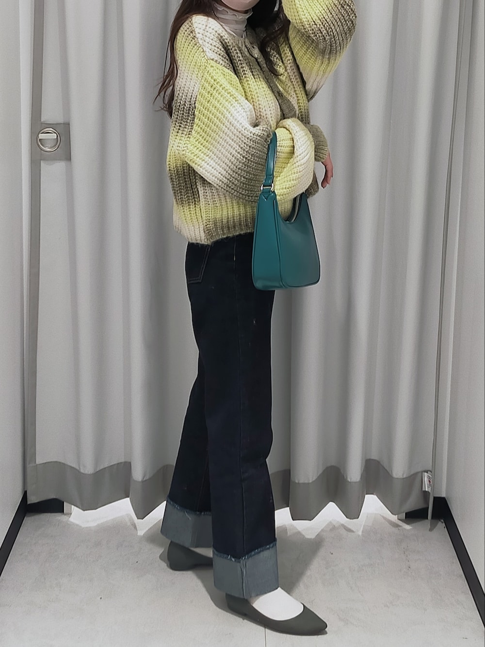 ブルー系のデニムパンツ、イエロー系のカーディガン/ボレロ、ブルー系のバッグを着用したレディースの秋コーディネートの2枚目の写真