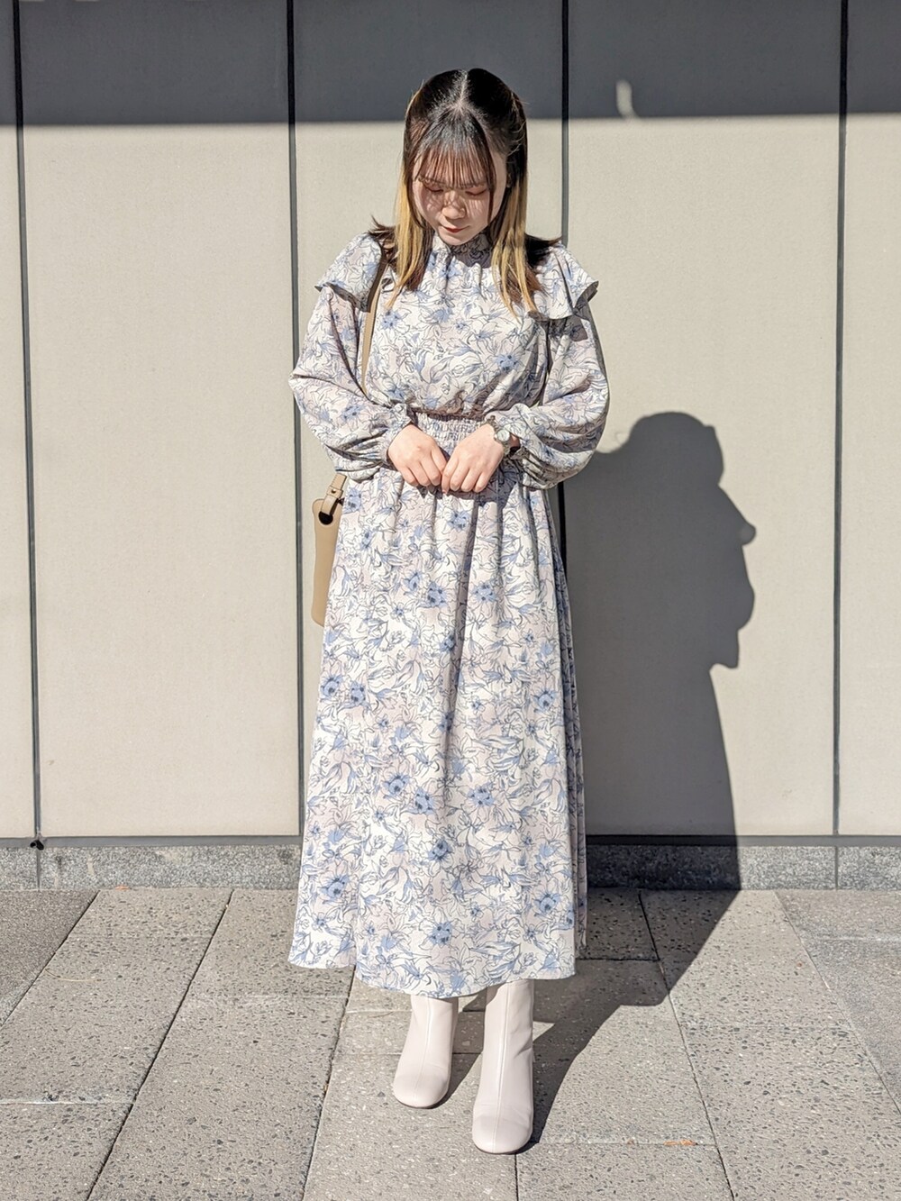 ベージュ系のトートバッグ、ベージュ系のブーツを着用したレディースの冬コーディネートの2枚目の写真