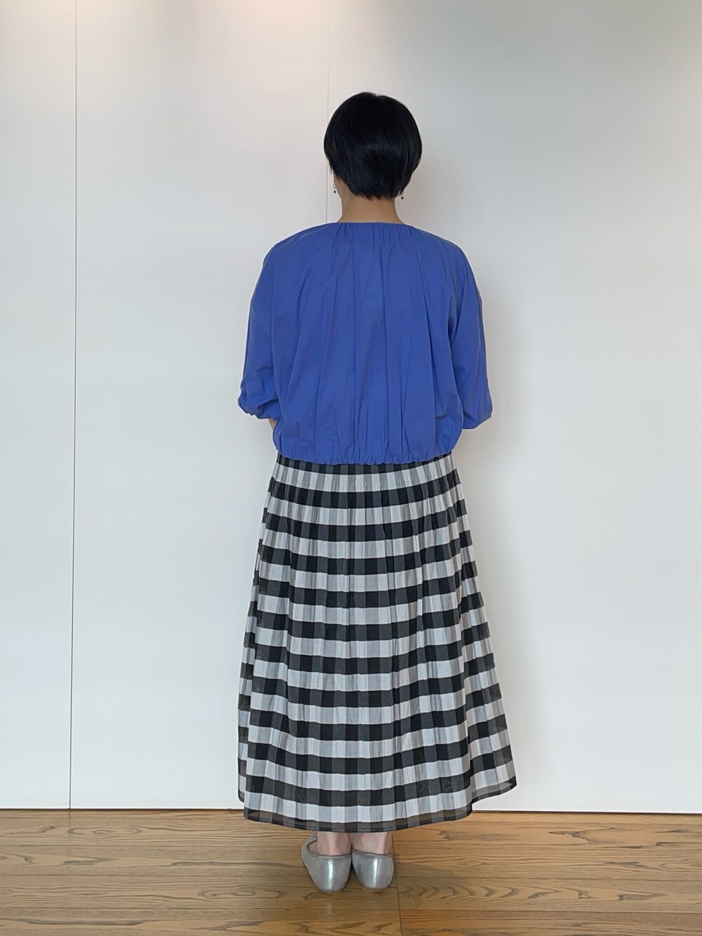 ブルー系のブルゾン、ブラック系のスカート、ブラック系のハンドバッグを着用したレディースの夏コーディネートの3枚目の写真