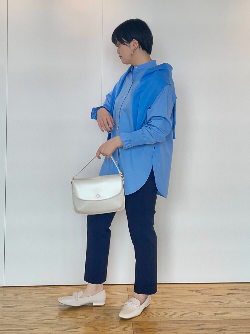 ブルー系のシャツ/ブラウス、ブルー系のカーディガン/ボレロ、ホワイト系のハンドバッグを着用したレディースの冬コーディネートの2枚目の写真