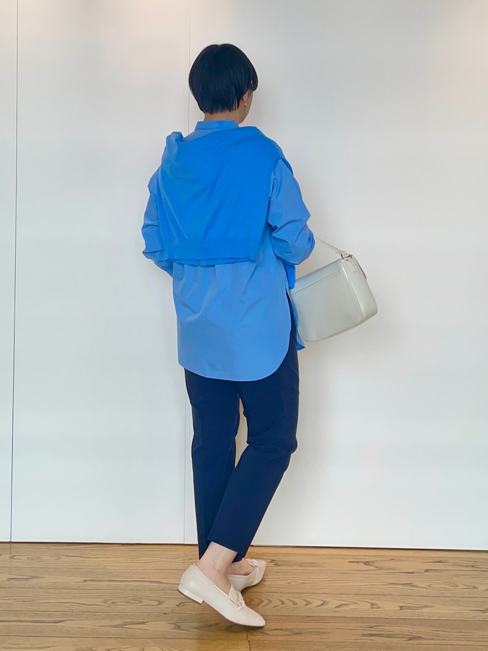 ブルー系のシャツ/ブラウス、ブルー系のカーディガン/ボレロ、ホワイト系のハンドバッグを着用したレディースの冬コーディネートの3枚目の写真