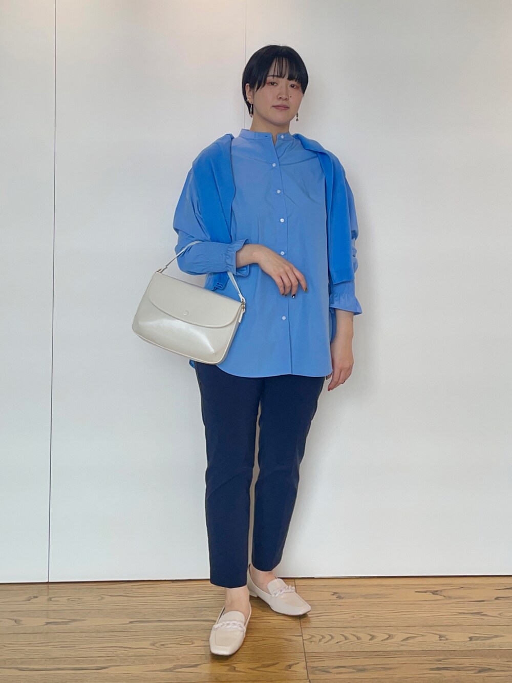 ブルー系のシャツ/ブラウス、ブルー系のカーディガン/ボレロ、ホワイト系のハンドバッグを着用したレディースの冬コーディネートの4枚目の写真