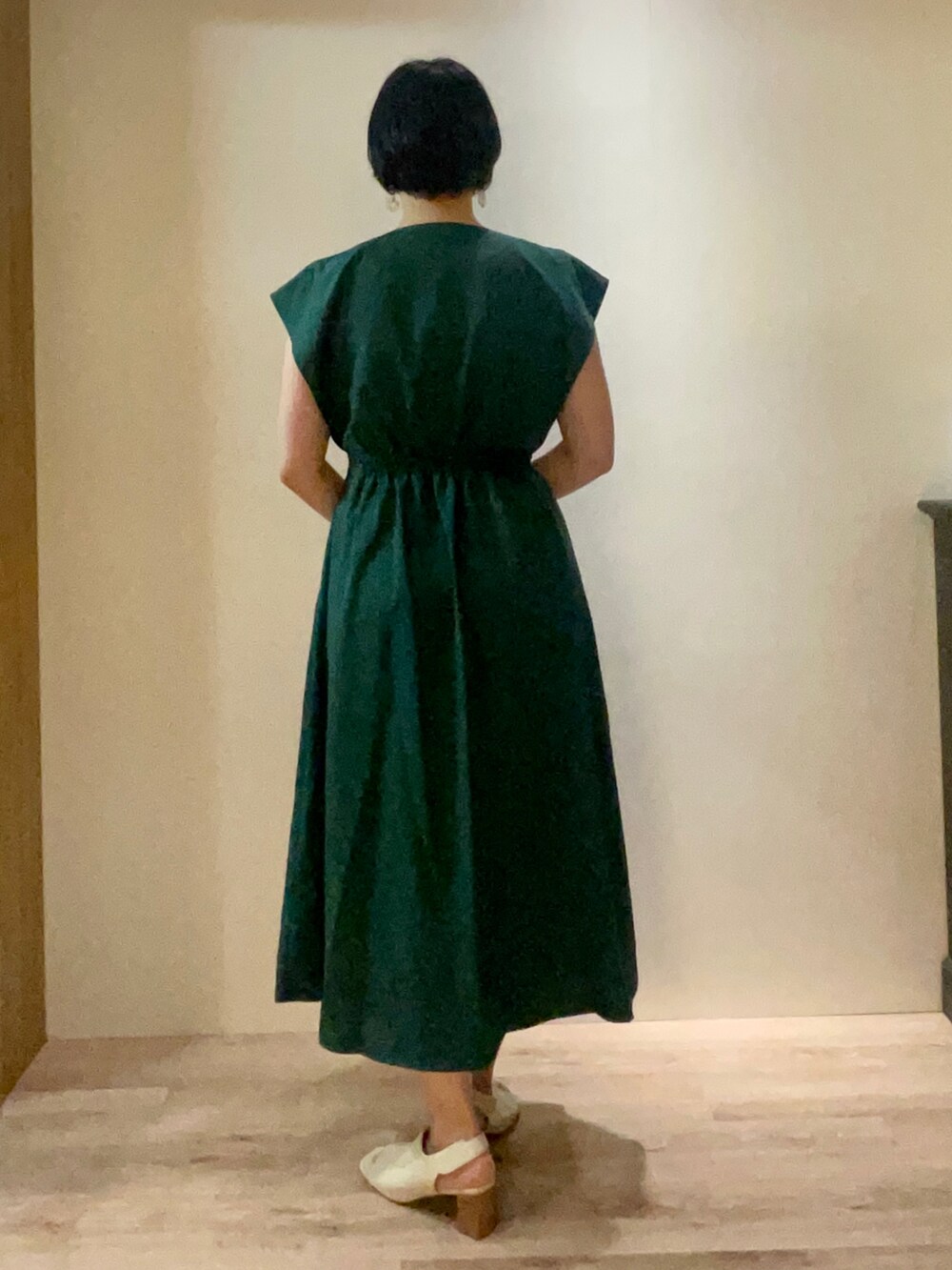 ホワイト系のハンドバッグ、グリーン系のワンピースを着用したレディースの夏コーディネートの3枚目の写真