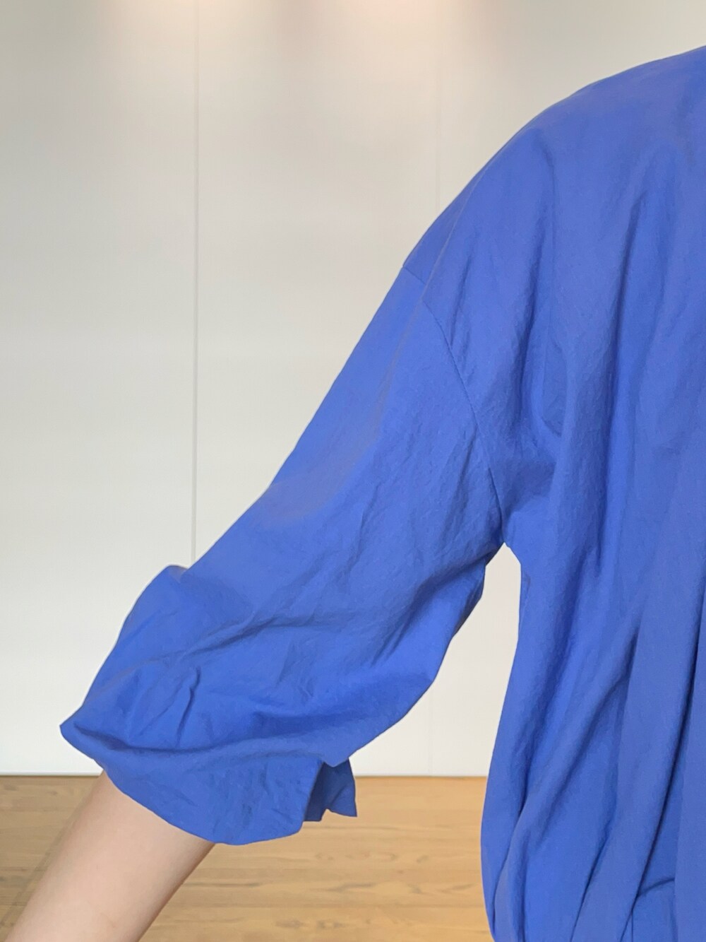 ブルー系のブルゾン、ブラック系のスカート、ブラック系のハンドバッグを着用したレディースの夏コーディネートの4枚目の写真