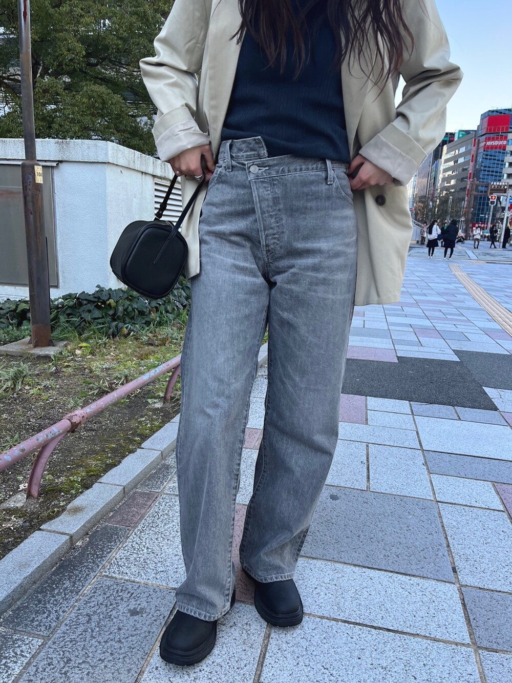 ベージュ系のテーラードジャケット、グレー系のタンクトップ、ブラック系のデニムパンツを着用したレディースの冬コーディネートの5枚目の写真