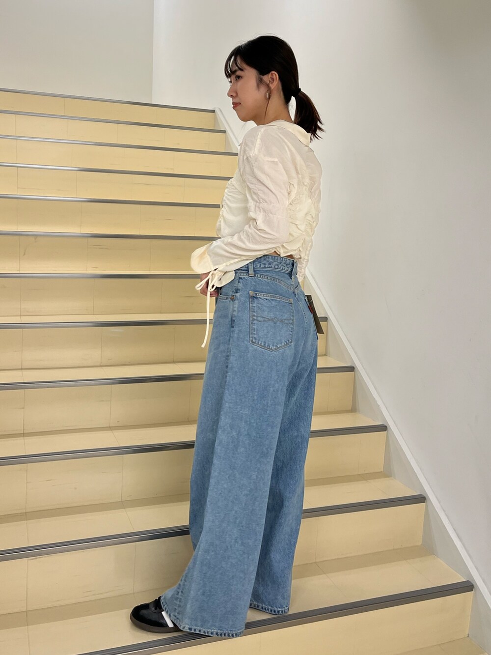 ホワイト系のシャツ/ブラウス、ブルー系のデニムパンツを着用したレディースの秋コーディネートの3枚目の写真
