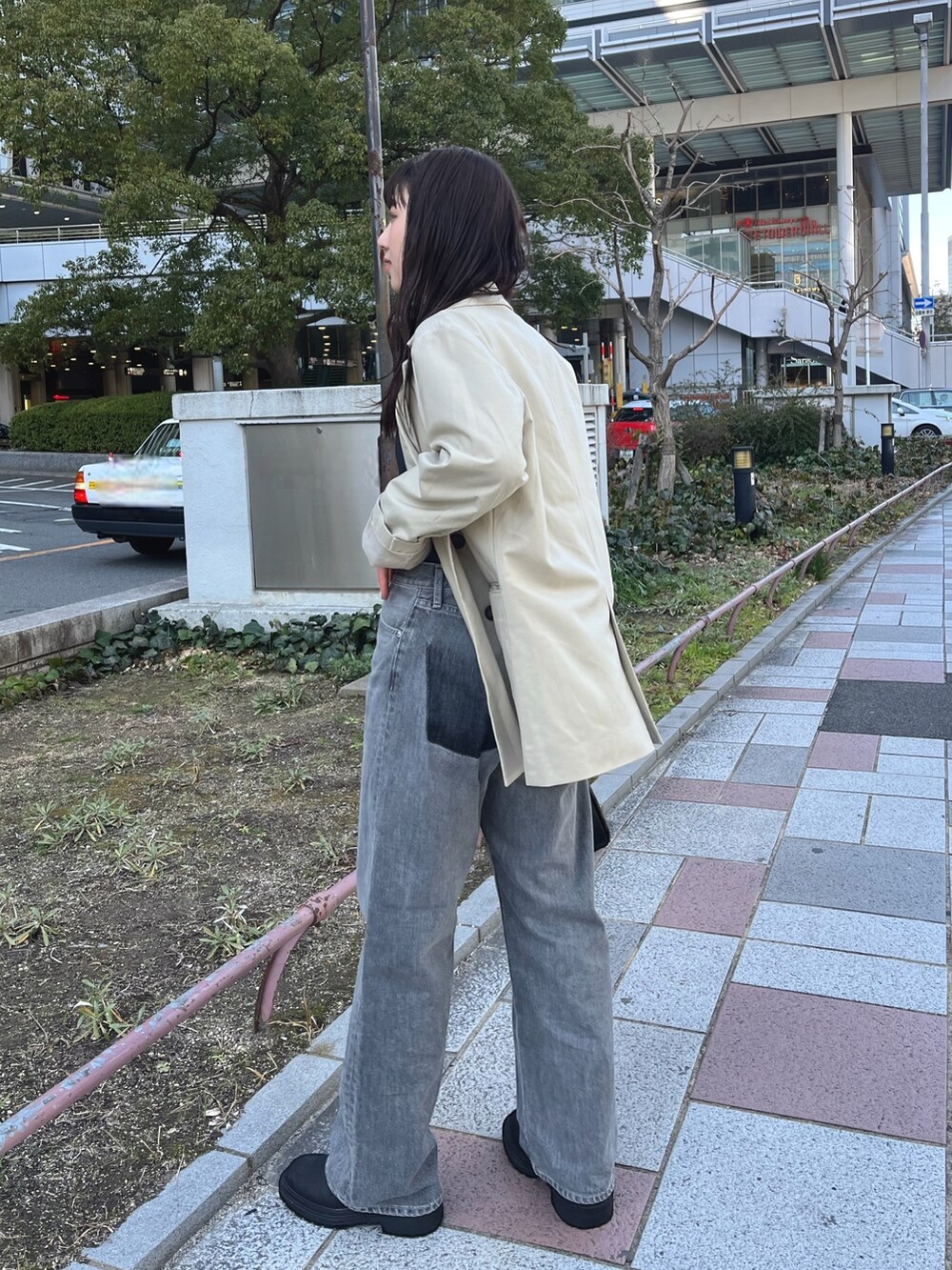 ベージュ系のテーラードジャケット、グレー系のタンクトップ、ブラック系のデニムパンツを着用したレディースの冬コーディネートの3枚目の写真