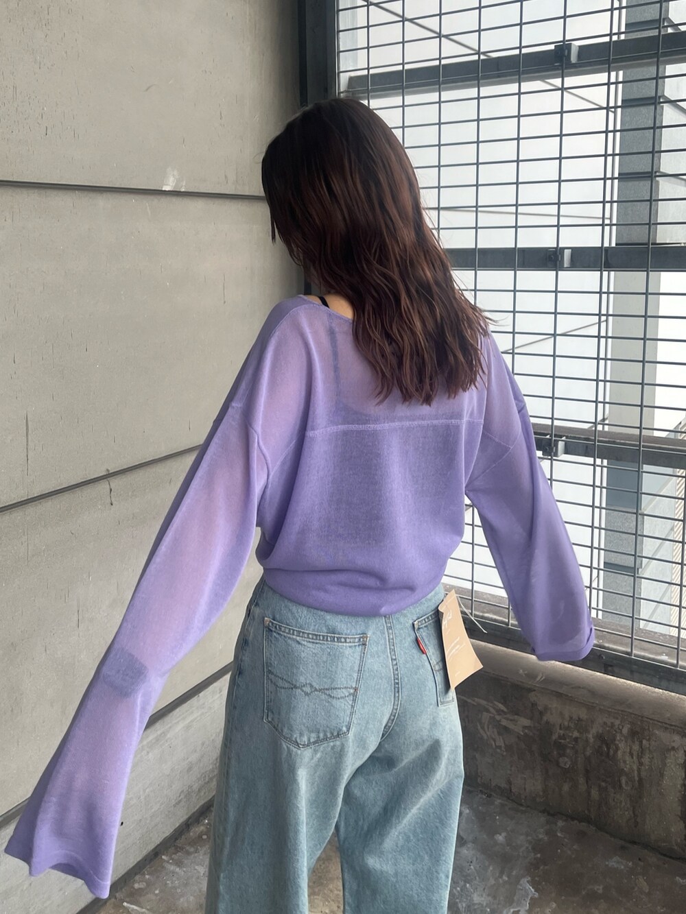 パープル系のニット/セーター、ブルー系のデニムパンツを着用したレディースの春コーディネートの5枚目の写真