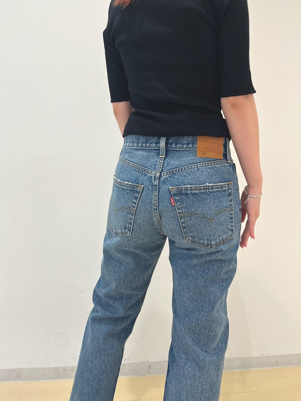 ブラック系のカーディガン/ボレロ、ブルー系のデニムパンツ、ブラック系の水着を着用したレディースの夏コーディネートの5枚目の写真