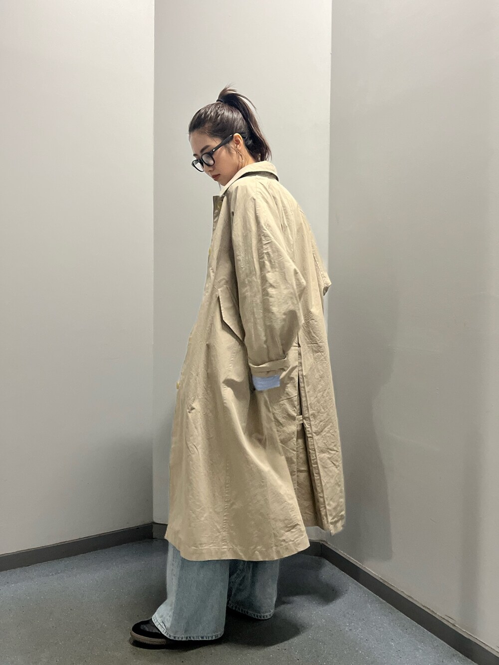 ベージュ系のステンカラーコート、その他のシャツ/ブラウス、ブルー系のデニムパンツを着用したレディースの冬コーディネートの4枚目の写真