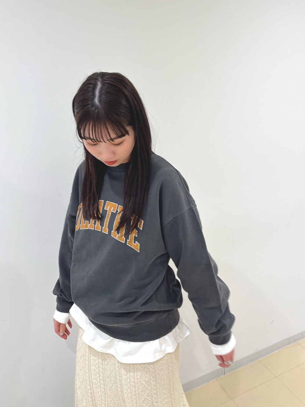 グレー系のTシャツ/カットソー、ホワイト系のTシャツ/カットソー、ホワイト系のスカートを着用したレディースの冬コーディネートの4枚目の写真