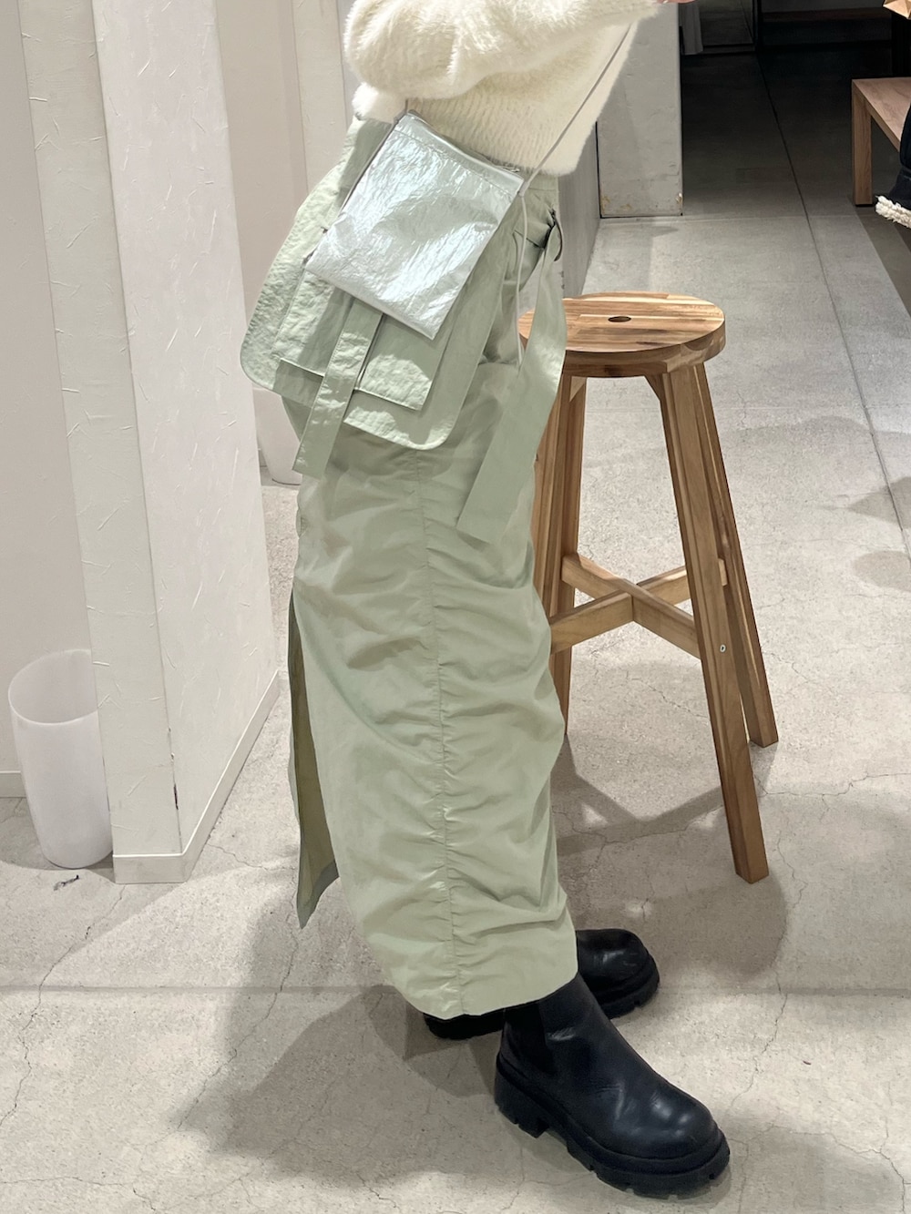 シルバー系のショルダーバッグ、グリーン系のスカートを着用したレディースの冬コーディネートの3枚目の写真