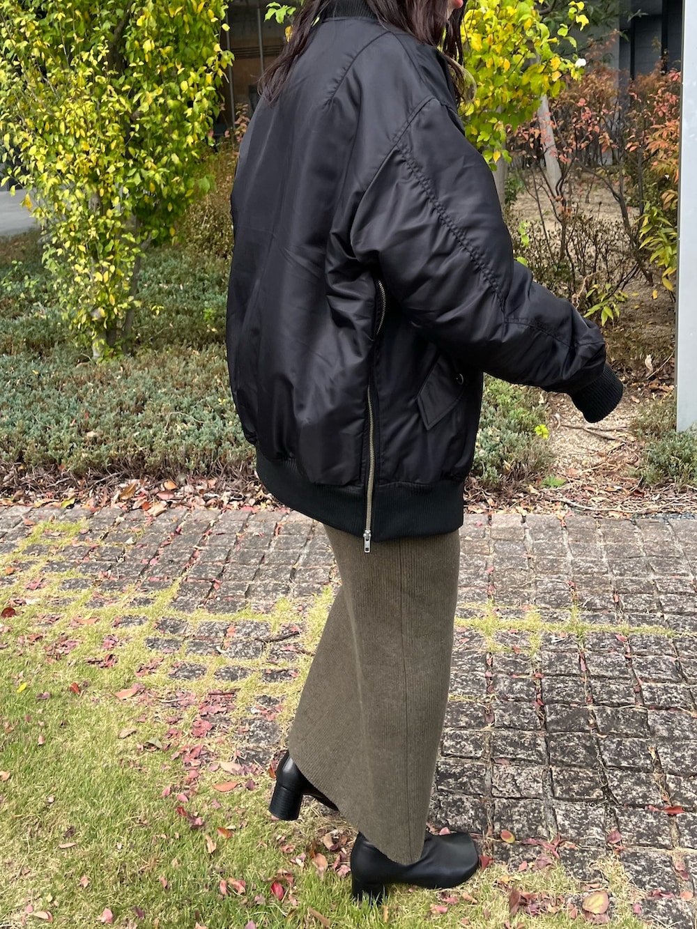 ブラック系のMA-1、グレー系のスウェット、グリーン系のスカートを着用したレディースの秋コーディネートの6枚目の写真