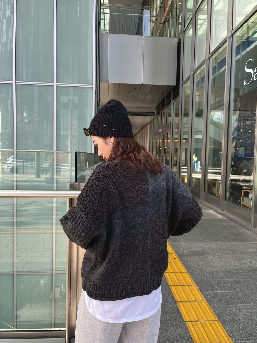 グレー系のニット/セーター、グレー系のその他パンツを着用したレディースの秋コーディネートの5枚目の写真