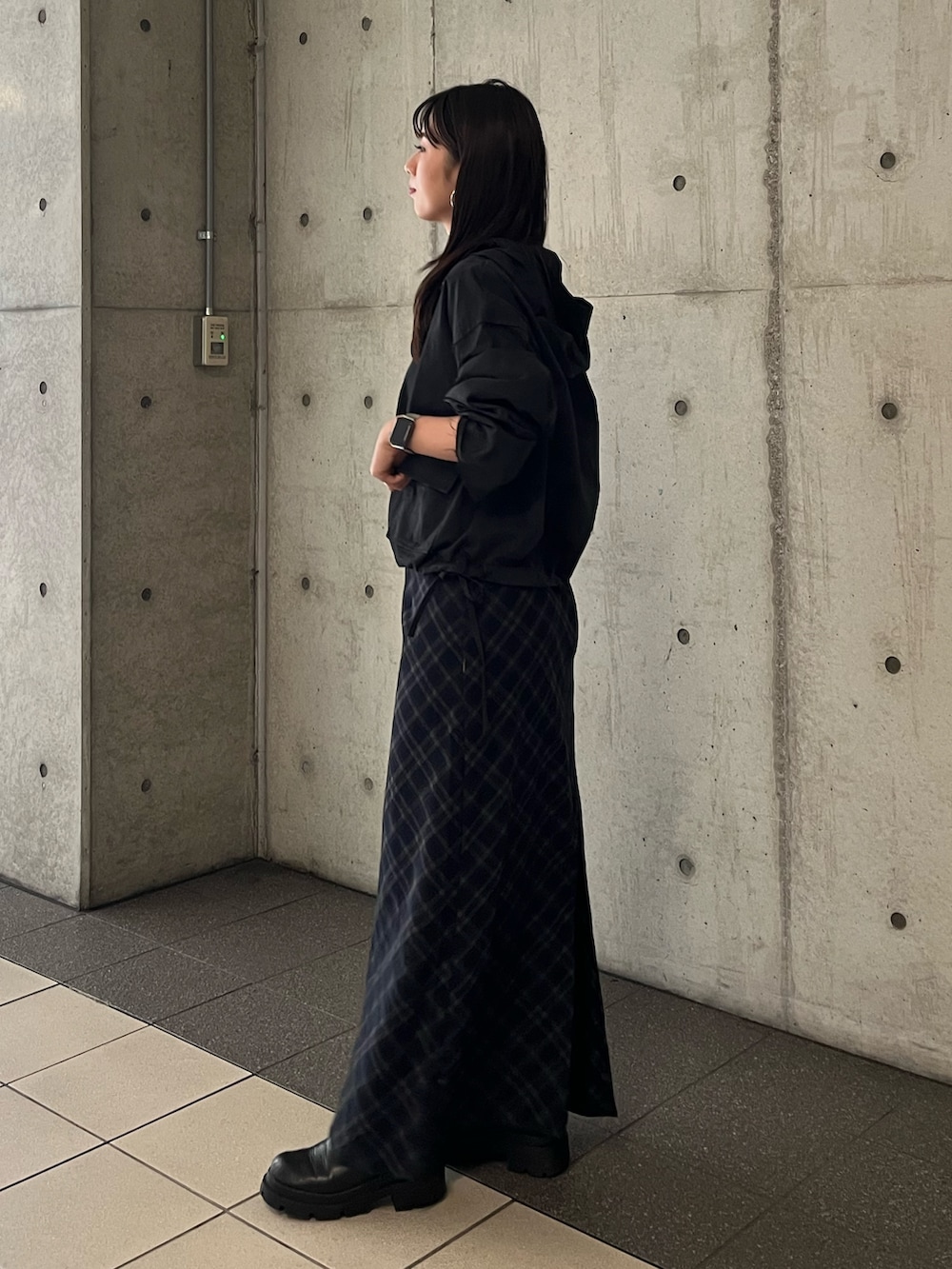 ブラック系のパーカー、ブルー系のスカートを着用したレディースの秋コーディネートの2枚目の写真