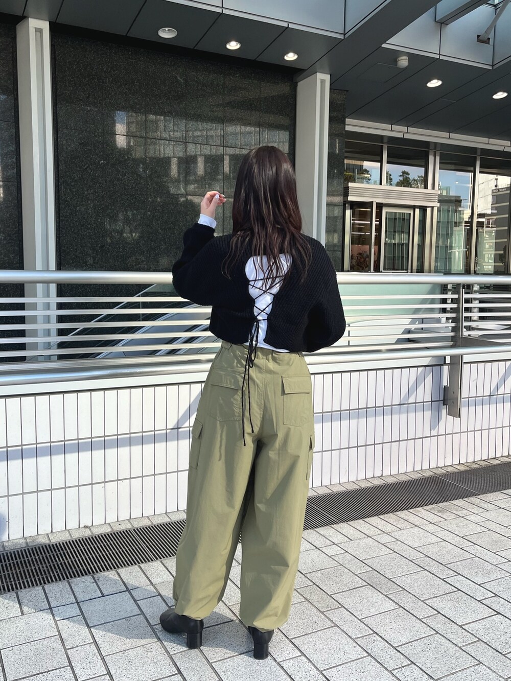 ブラック系のワンピース、グリーン系のカーゴパンツ、ブラック系のハンドバッグを着用したレディースの冬コーディネートの4枚目の写真