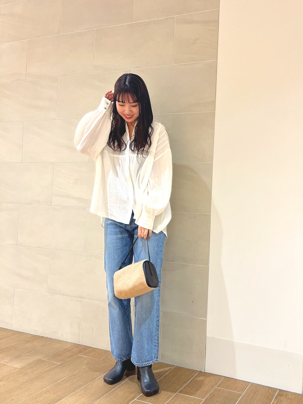 ホワイト系のシャツ/ブラウス、ブルー系のデニムパンツ、その他のハンドバッグを着用したレディースの冬コーディネートの3枚目の写真