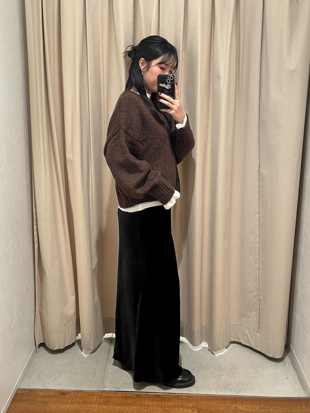 ブラウン系のニット/セーター、ブラック系のスカートを着用したレディースの秋コーディネートの2枚目の写真