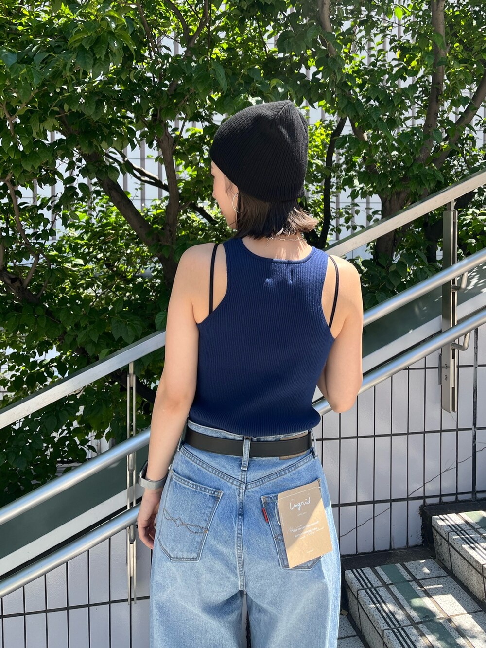 ブルー系のタンクトップ、ブルー系のデニムパンツ、ブラック系のベルトを着用したレディースの夏コーディネートの6枚目の写真