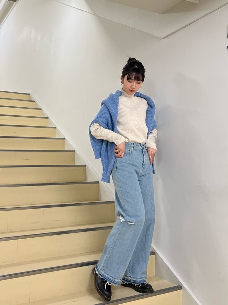 ブルー系のデニムパンツ、ホワイト系のニット/セーター、ブルー系のカーディガン/ボレロを着用したレディースの秋コーディネートの2枚目の写真