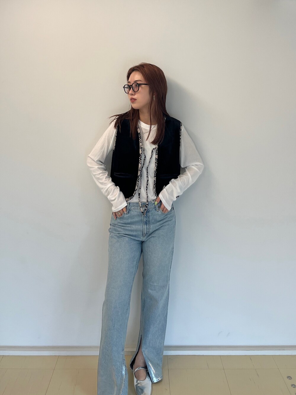 ブラック系のベスト、ホワイト系のTシャツ/カットソー、ブルー系のデニムパンツを着用したレディースの夏コーディネートの2枚目の写真