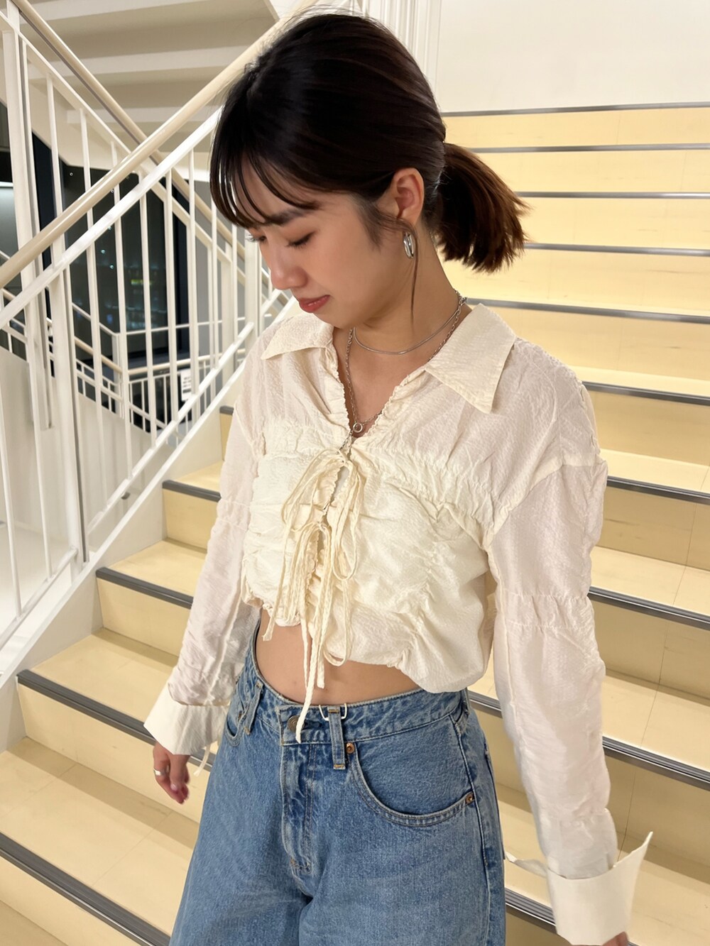 ホワイト系のシャツ/ブラウス、ブルー系のデニムパンツを着用したレディースの秋コーディネートの5枚目の写真