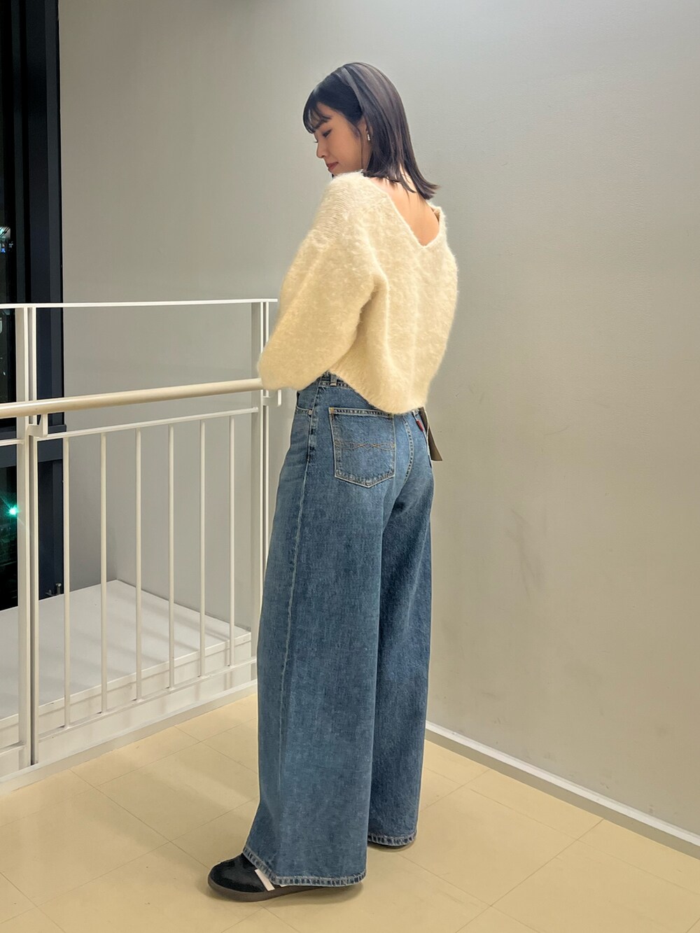ホワイト系のニット/セーター、ブルー系のデニムパンツを着用したレディースの秋コーディネートの2枚目の写真