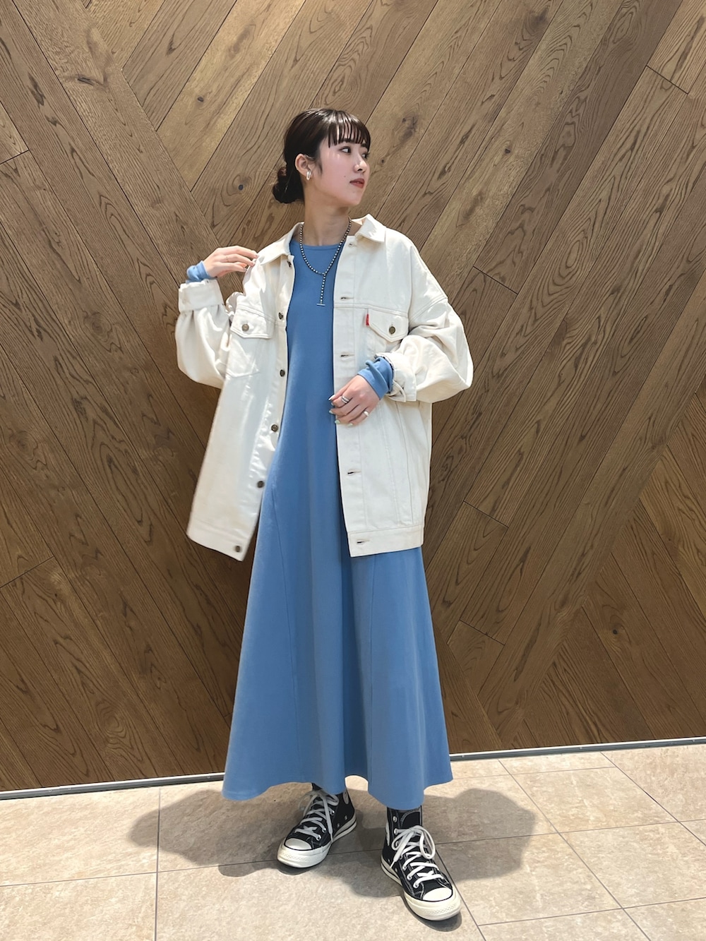 ホワイト系のデニムジャケット、シルバー系のネックレスを着用したレディースの春コーディネートの2枚目の写真
