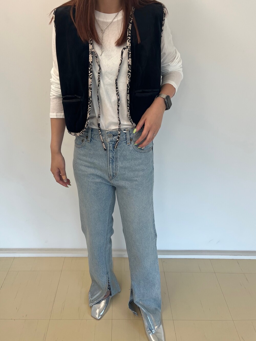 ブラック系のベスト、ホワイト系のTシャツ/カットソー、ブルー系のデニムパンツを着用したレディースの夏コーディネートの3枚目の写真