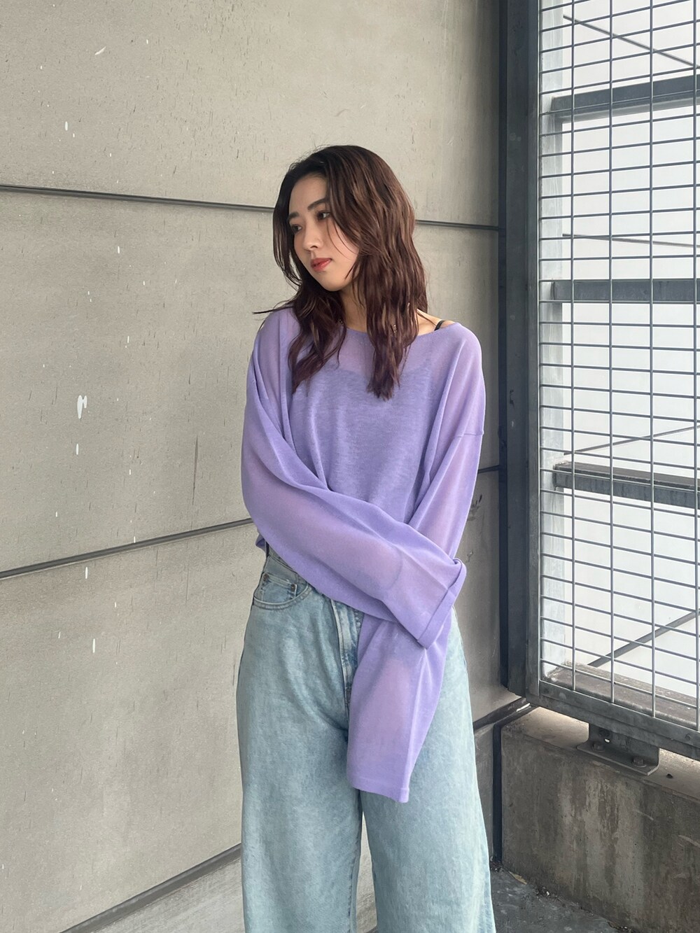 パープル系のニット/セーター、ブルー系のデニムパンツを着用したレディースの春コーディネートの4枚目の写真