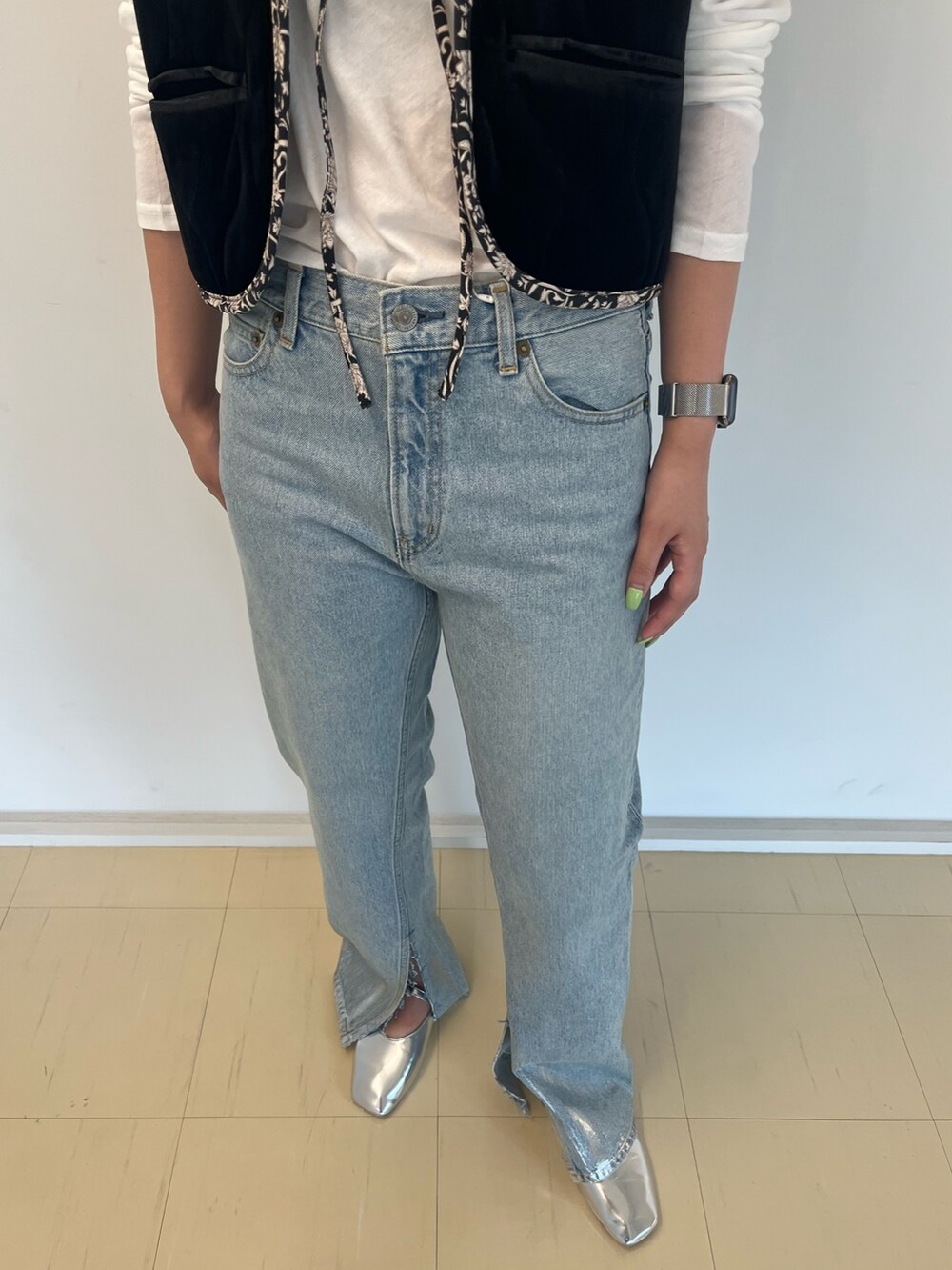 ブラック系のベスト、ホワイト系のTシャツ/カットソー、ブルー系のデニムパンツを着用したレディースの夏コーディネートの4枚目の写真