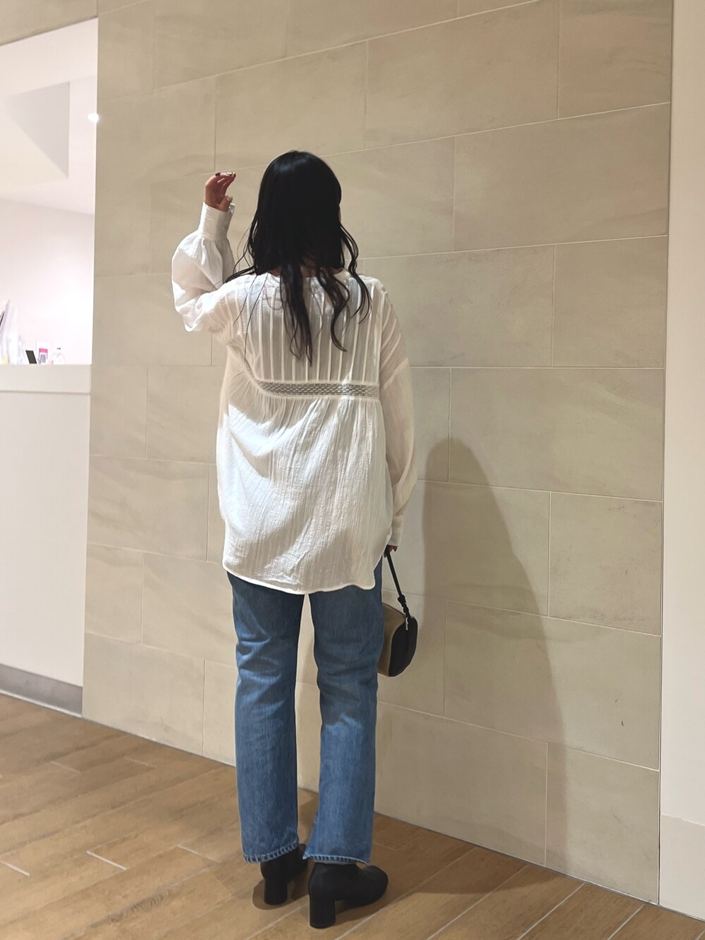 ホワイト系のシャツ/ブラウス、ブルー系のデニムパンツ、その他のハンドバッグを着用したレディースの冬コーディネートの5枚目の写真