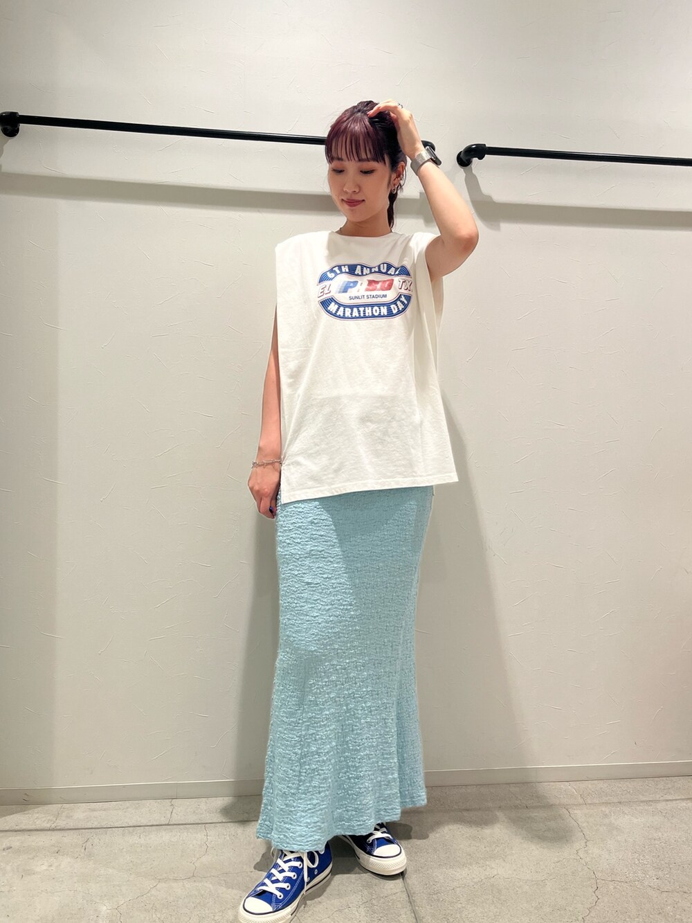 ホワイト系のタンクトップ、ブルー系のスカート、ブルー系のスニーカーを着用したレディースの夏コーディネートの2枚目の写真