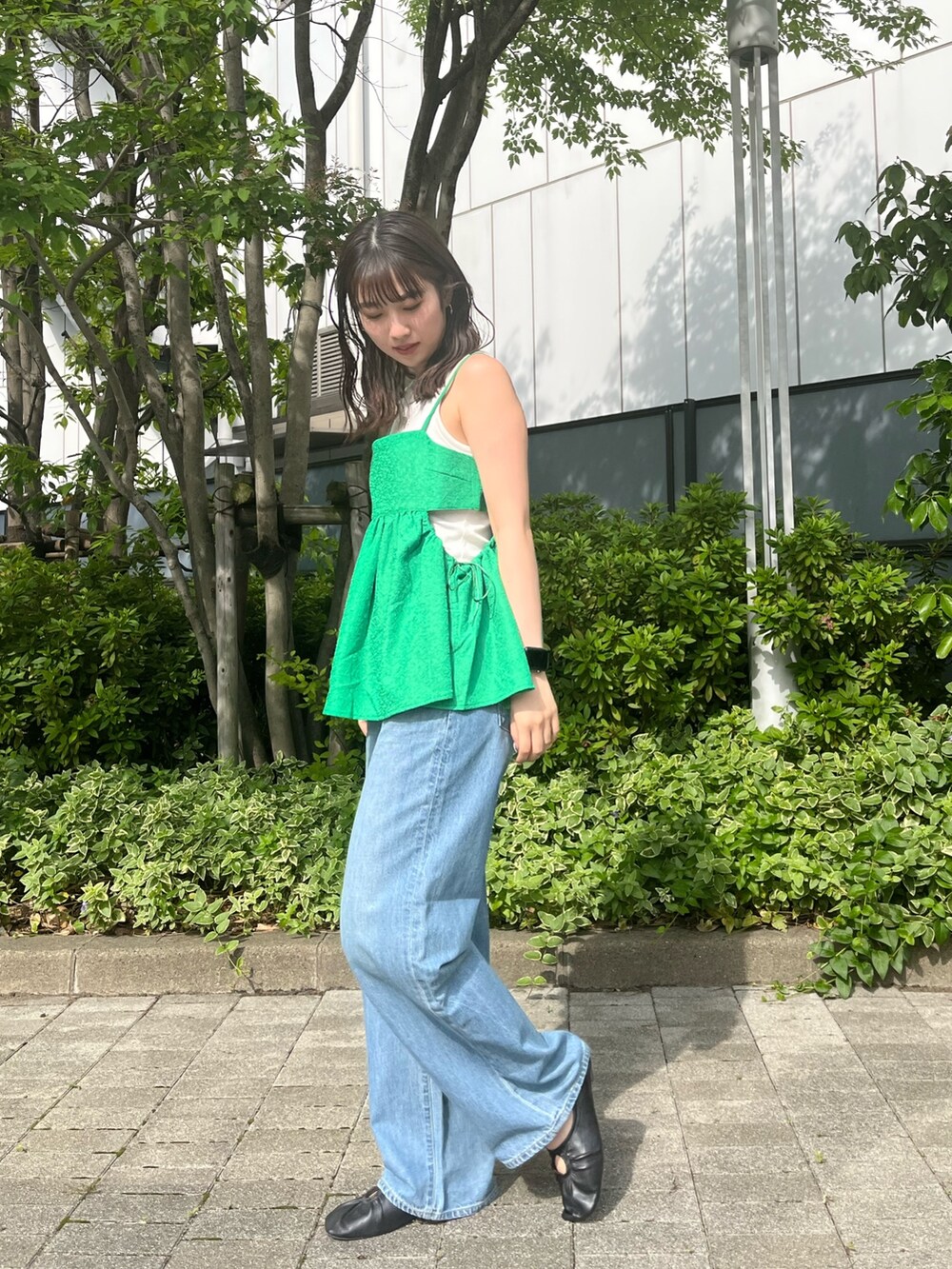 グリーン系のシャツ/ブラウス、ブルー系のデニムパンツを着用したレディースの春コーディネートの2枚目の写真