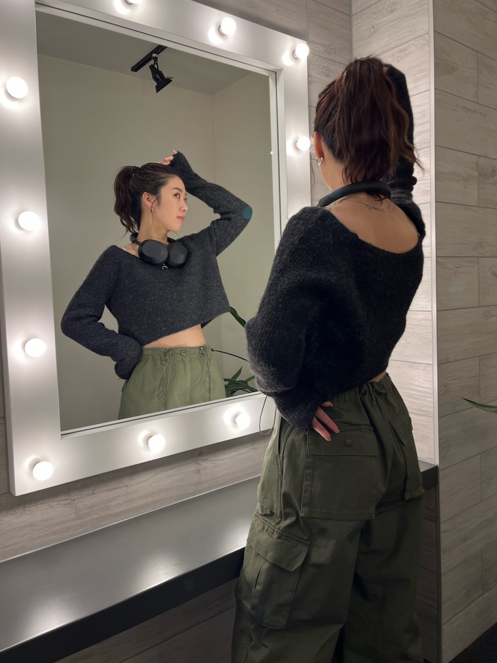 グレー系のニット/セーター、グリーン系のカーゴパンツ、ブラック系のブーツを着用したレディースの秋コーディネートの3枚目の写真