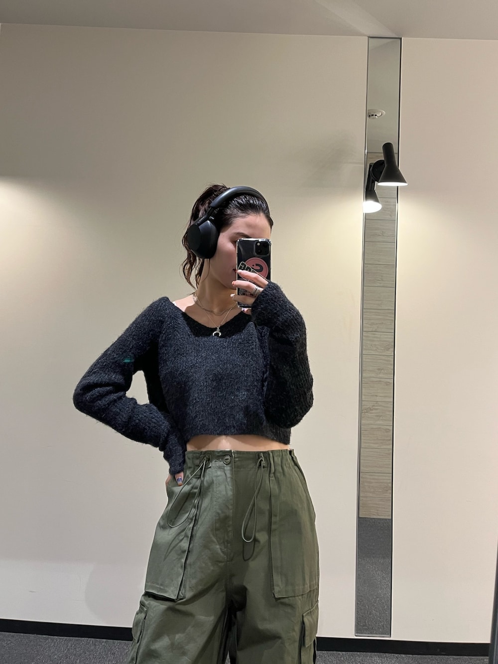 グレー系のニット/セーター、グリーン系のカーゴパンツ、ブラック系のブーツを着用したレディースの秋コーディネートの2枚目の写真