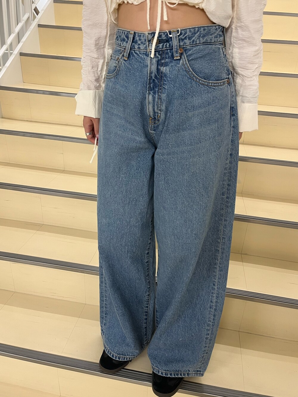 ホワイト系のシャツ/ブラウス、ブルー系のデニムパンツを着用したレディースの秋コーディネートの6枚目の写真