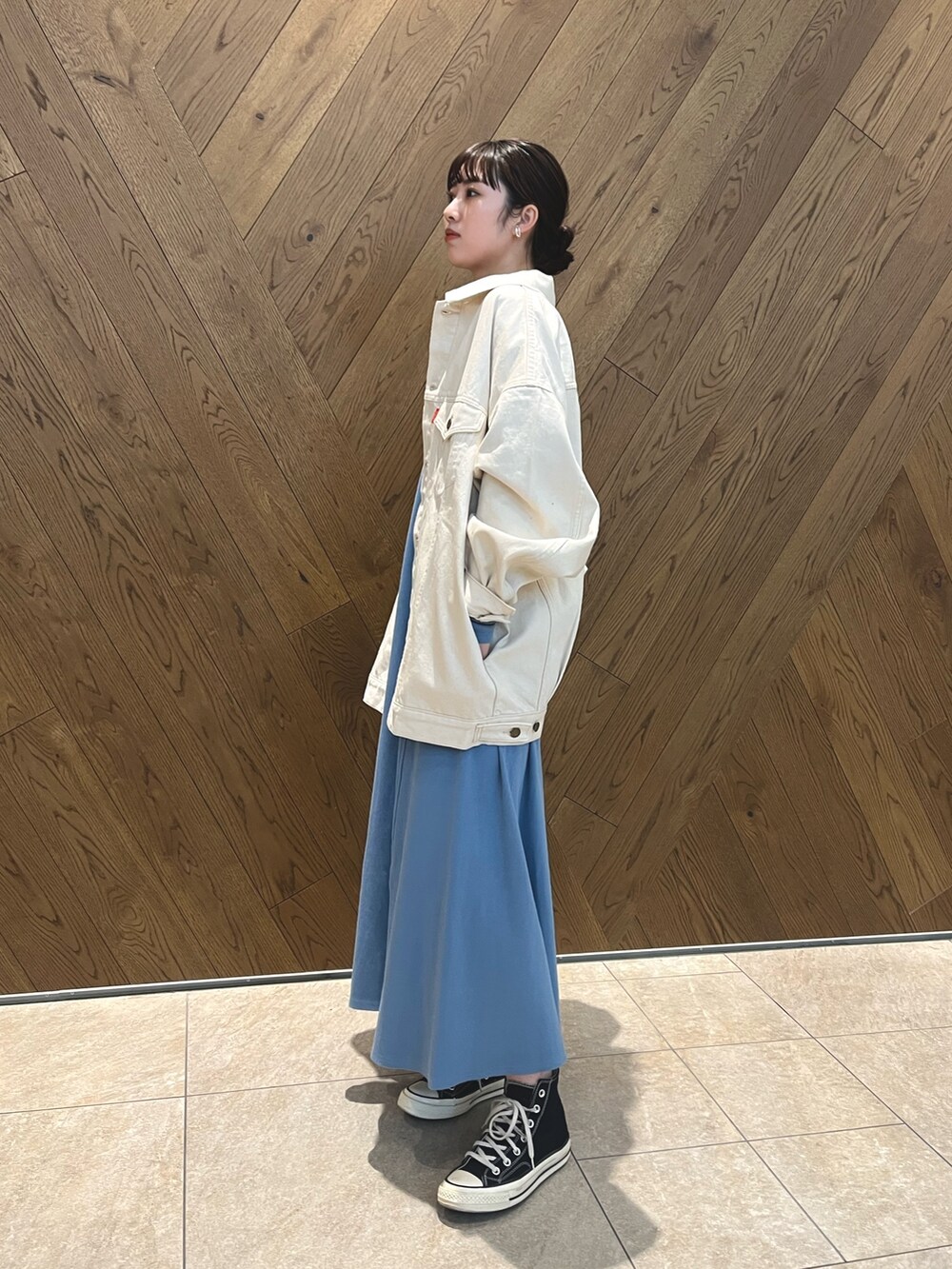 ホワイト系のデニムジャケット、シルバー系のネックレスを着用したレディースの春コーディネートの3枚目の写真