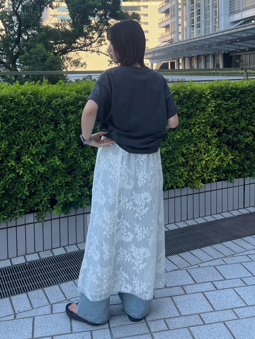 グレー系のTシャツ/カットソー、ホワイト系のワンピース、ブルー系のデニムパンツを着用したレディースの夏コーディネートの4枚目の写真