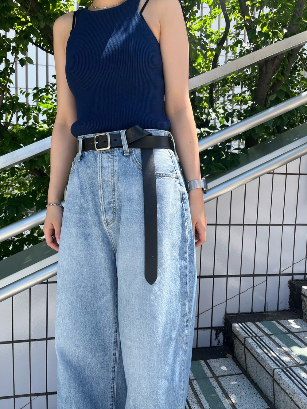 ブルー系のタンクトップ、ブルー系のデニムパンツ、ブラック系のベルトを着用したレディースの夏コーディネートの7枚目の写真