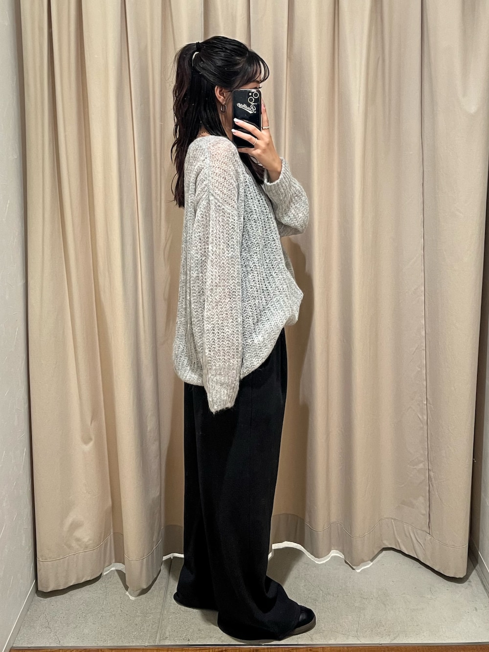 グレー系のニット/セーター、グレー系のスウェットパンツを着用したレディースの秋コーディネートの2枚目の写真