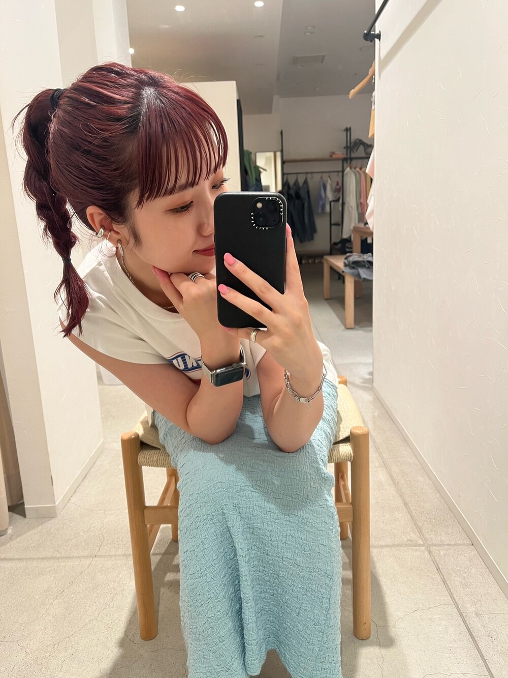 ホワイト系のタンクトップ、ブルー系のスカート、ブルー系のスニーカーを着用したレディースの夏コーディネートの3枚目の写真